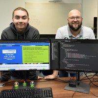 Julian Kugler und Ausbilder Stefan Bautz präsentieren den Webauftritt der Pflegejobmesse.