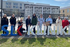 BBW-Auszubildende stehen hinter dem Schriftzug und vor dem Gebäude der SLK-Kliniken in Heilbronn
